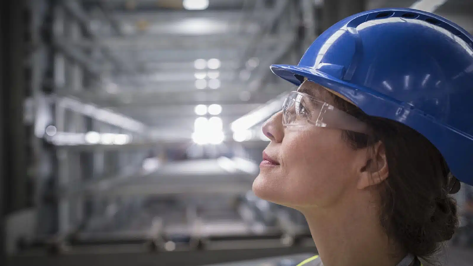 Female Factory Worker In A Blue Hard Hat Stock Photo
