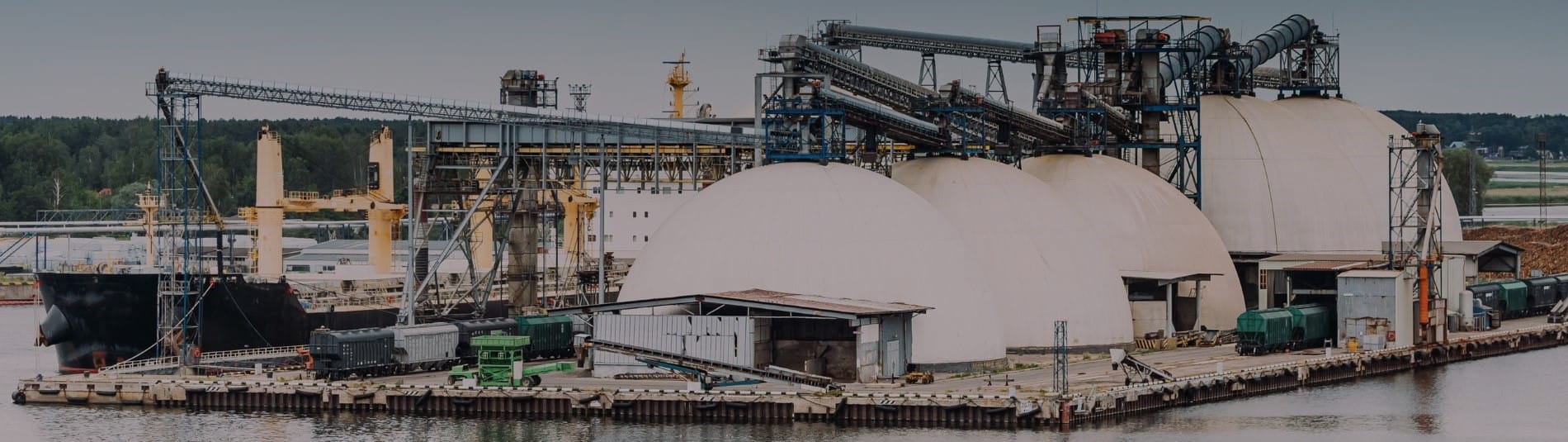 Photo of chemical storage tanks and equipment at busy intermodal shipping port.